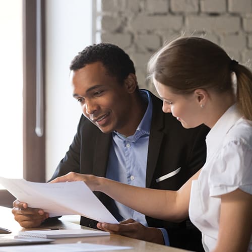 man and woman in professional setting looking at paperwork