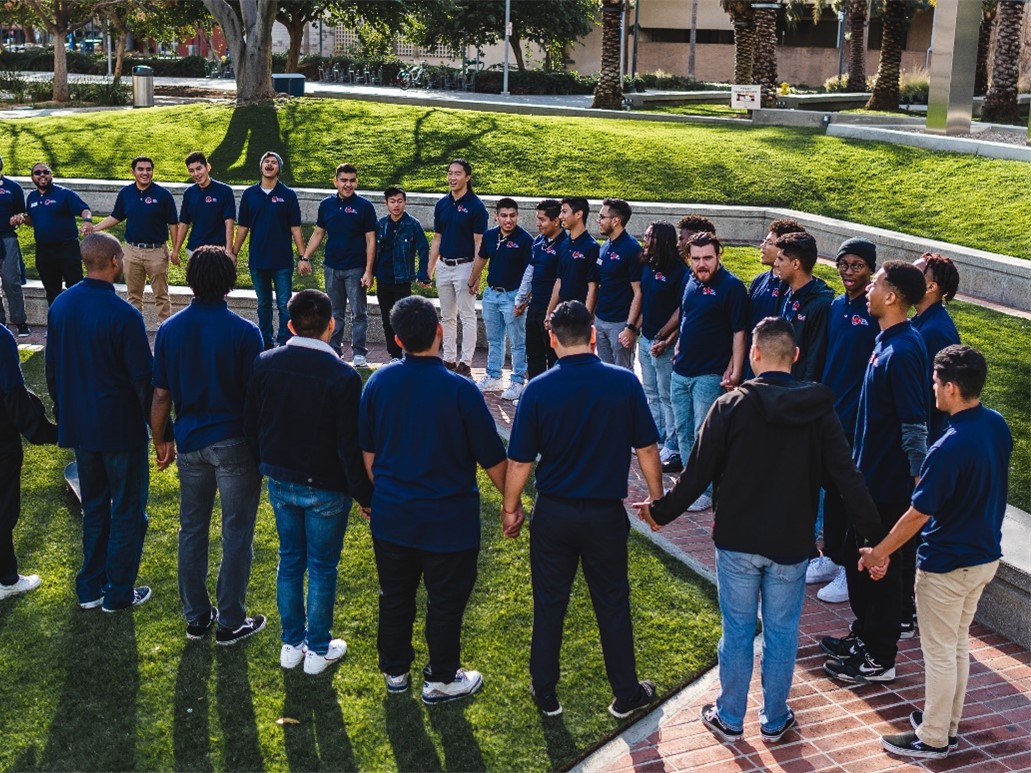 students-holding-hands-outside-in-circle