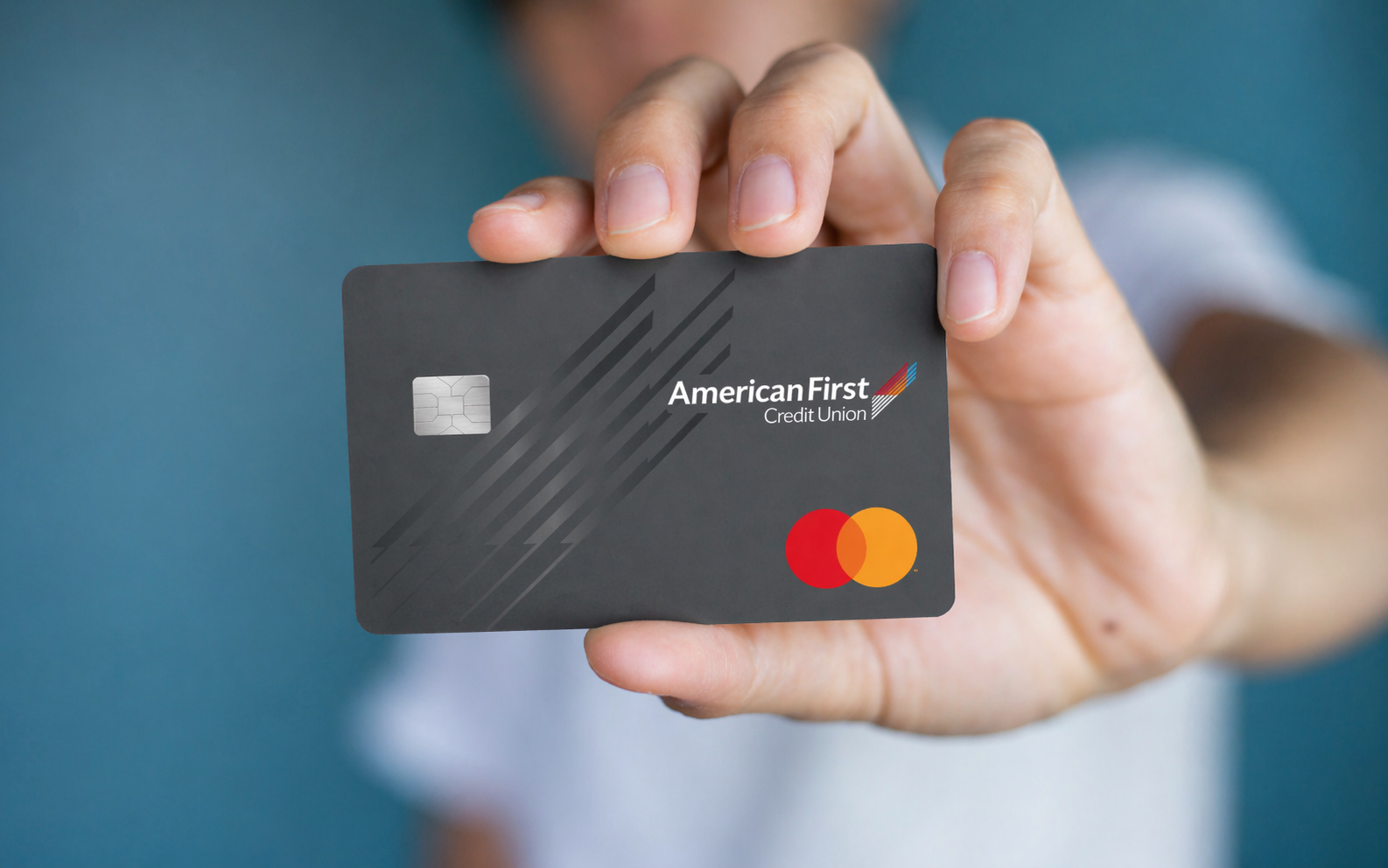 Man holding an AFCU Credit Card with Rewards
