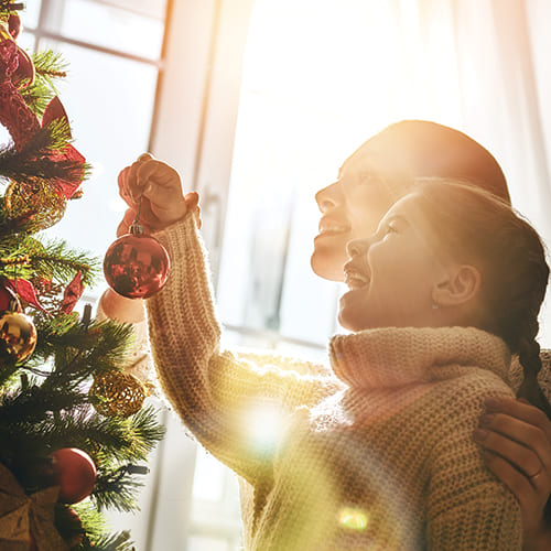 mother and daughter putting up a christmas tree