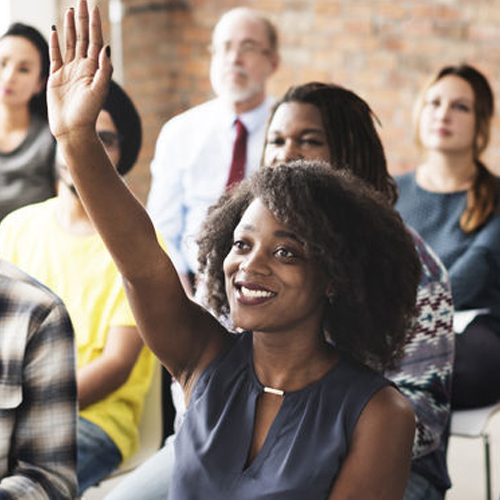 woman in classroom raising hand